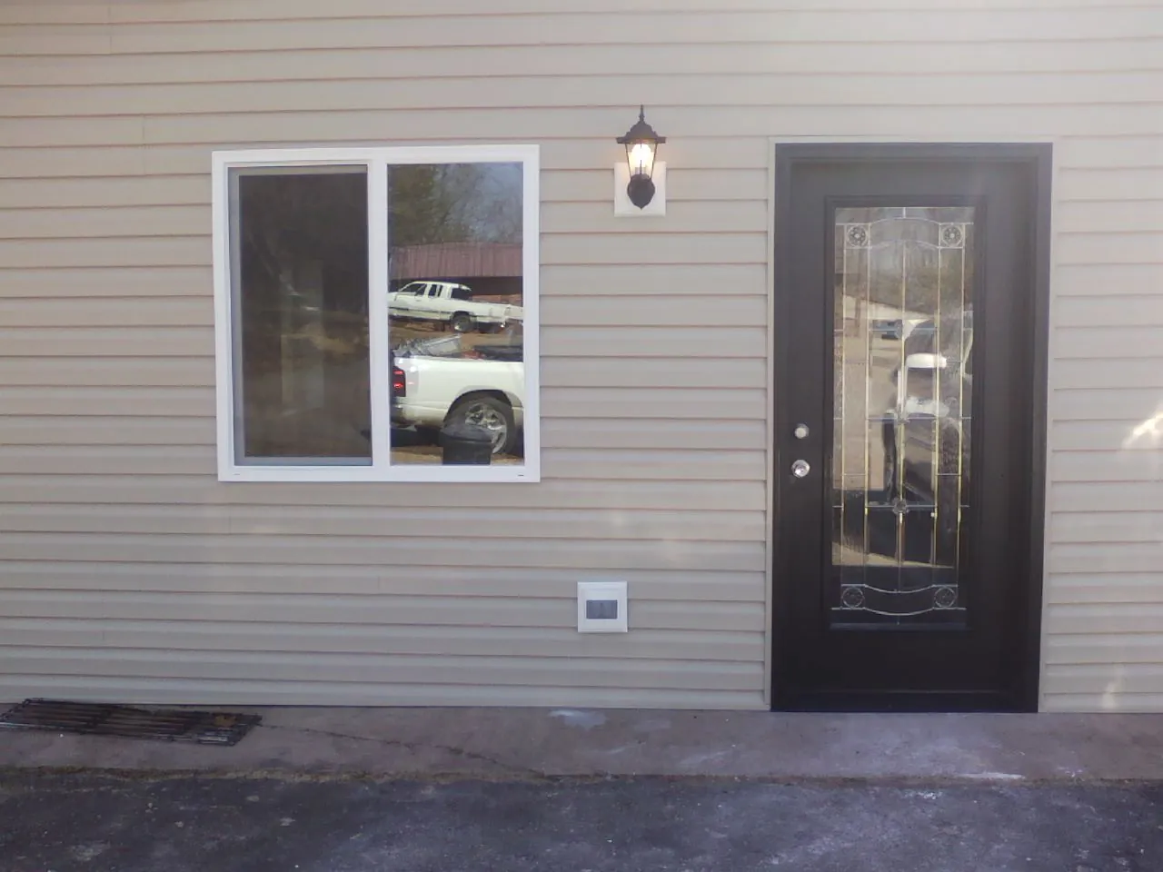 New siding, window and entry door on the side of an addition in West Memphis
