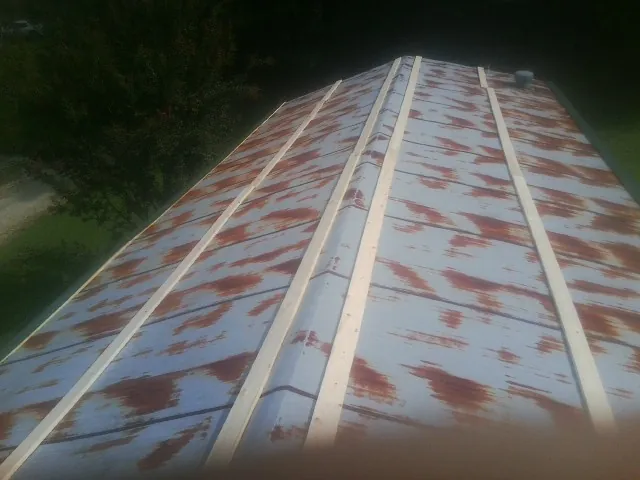 Rusted metal roof panels with new wood purlins before replacement — Storm Damage Roof Repair in West Memphis by Roofing Brothers