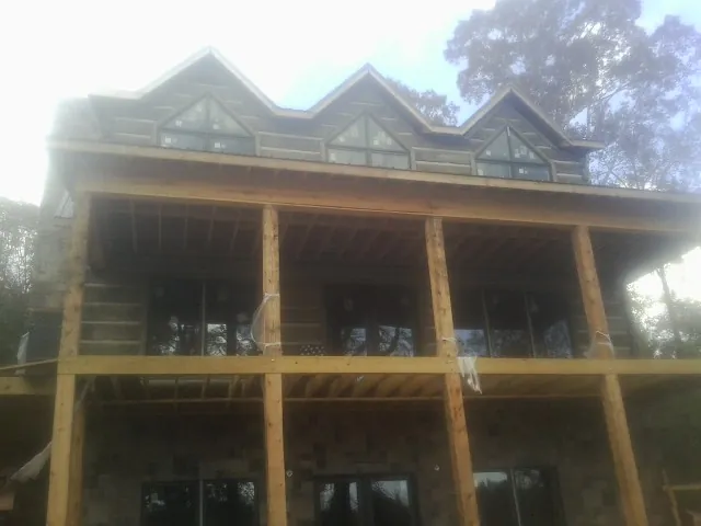 Dormers and porch framing on a large log home under construction — Roof Coating work by our crew in West Memphis