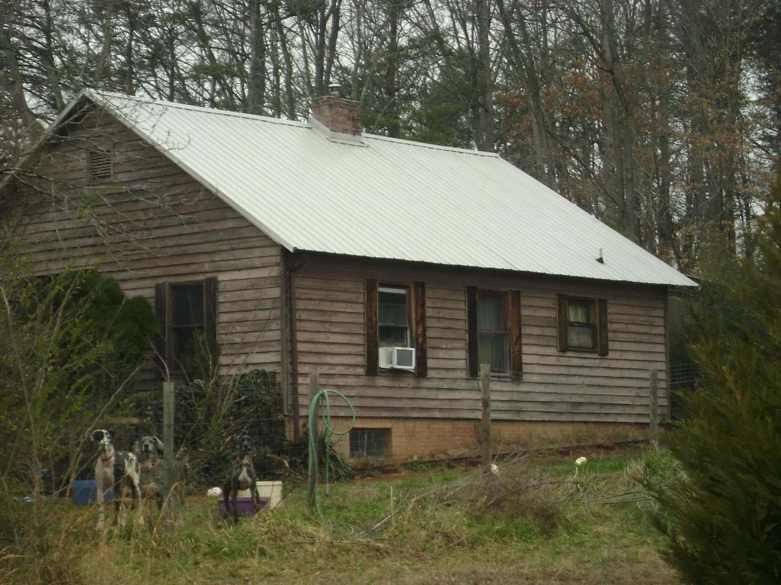White metal roof on an old wood sided farmhouse, from a Metal Roof Installation job in West Memphis